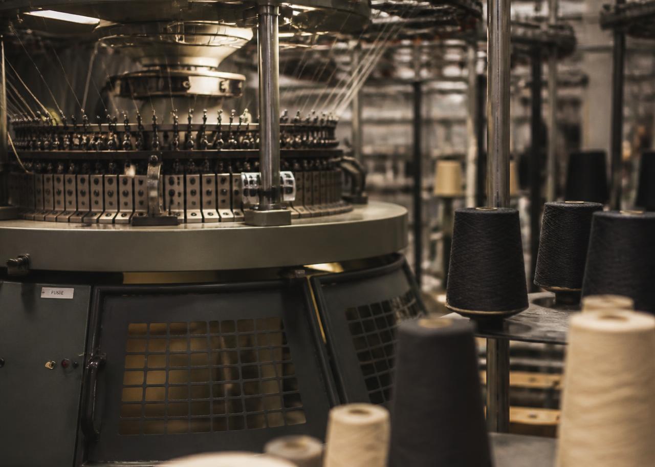 Circular knitting machine and yarn cones in a Northern Italian hosiery mill